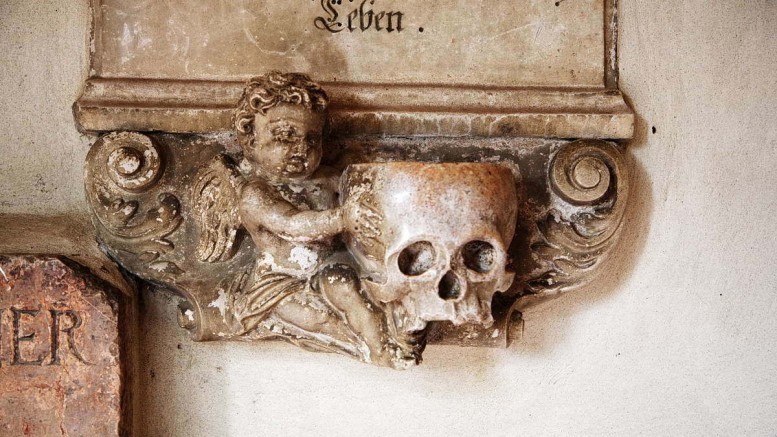Totenkopf auf einer Grabtafel an der Stiftkirche Laufen. Foto: KTraintinger