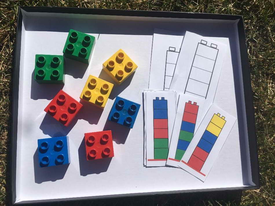 Das Ausgangsmaterial für dieses Lernarrangement sind rote, gelbe, blaue und grüne quadratische Legosteine. Das Kind kann Türme in beliebiger Reihenfolge bauen, dann Vorlagen ausmalen oder nach Vorlagen Türme nachbauen. (Anna Windhofer)