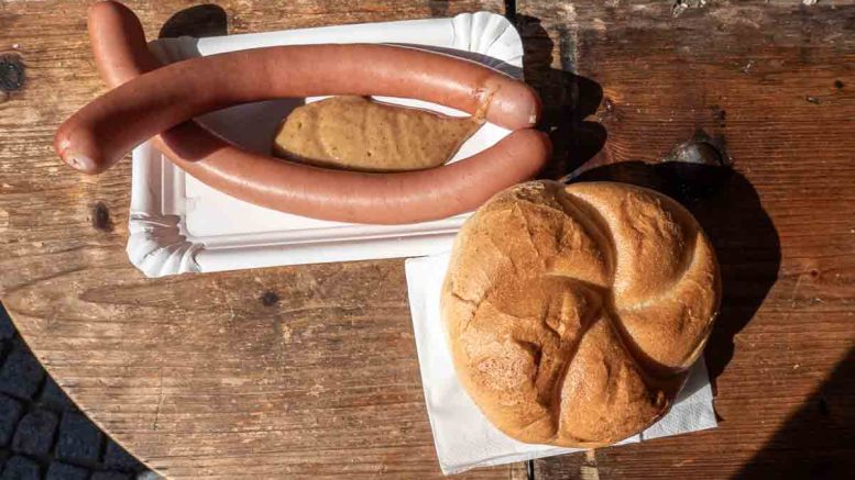 Ein Paar Frankfurter Würstel mit süssem Senf und einer Semmel