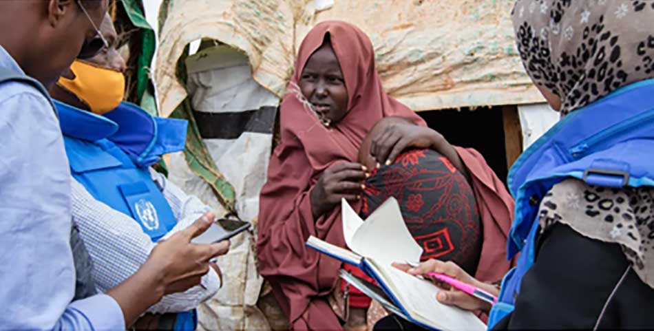 Madow Ahmed, Mutter von drei Kindern spricht mit Mitarbeitern von Hilfsorga-nisation im Yaqbarwe Lager für Vertriebene in Baidoa, in Somalia. Madow’s Familie wie die Bewohner des Flüchtlingslagers werden durch Hilfsorganisatio¬nen mit Geld, Medizin, durch den Bau von Wassertanks, Latrinen und Solarpa¬nels unterstützt. (Bild: OCHA)